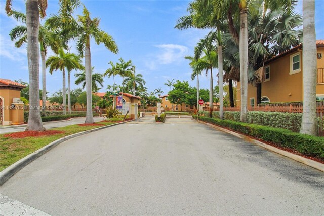 15445 SW 26th Ter, Miami, FL 33185 - view of asphalt road featuring traffic signs, curbs, and a gated entry