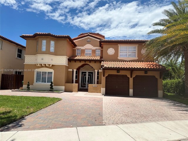 15445 SW 26th Ter, Miami, FL 33185 - mediterranean / spanish-style house featuring stucco siding, decorative driveway, an attached garage, and a tile roof
