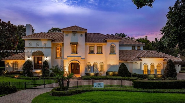 2211 Azalea Pl, Winter Park, FL 32789 - mediterranean / spanish-style house with a fenced front yard, a chimney, stucco siding, curved driveway, and a tiled roof