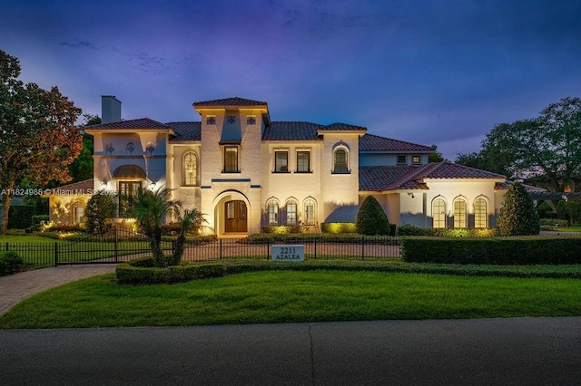 2211 Azalea Pl, Winter Park, FL 32789 - mediterranean / spanish house with a chimney, a fenced front yard, stucco siding, a tiled roof, and driveway