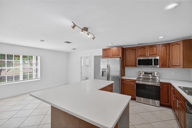 14861 SW 149th St, Miami, FL 33196 - kitchen with stainless steel appliances, light tile patterned floors, light countertops, a kitchen island, and brown cabinets