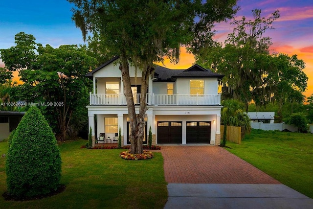2607 Lafayette Ave, Winter Park, FL 32789 - view of front facade with a balcony, decorative driveway, stucco siding, a front lawn, and an attached garage