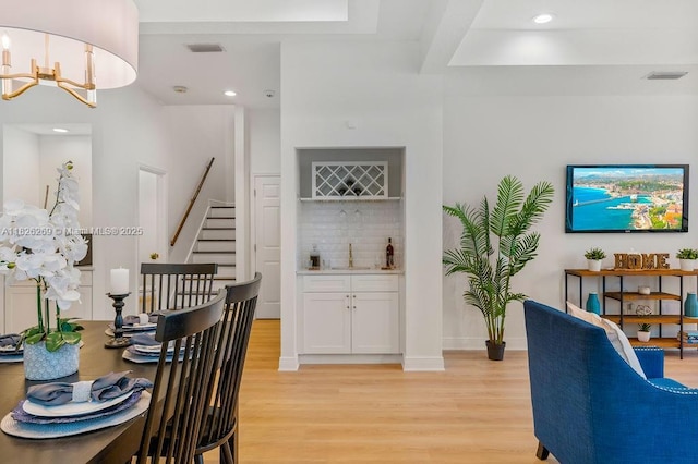 2607 Lafayette Ave, Winter Park, FL 32789 - dining room featuring bar, light wood-type flooring, stairs, recessed lighting, and a chandelier