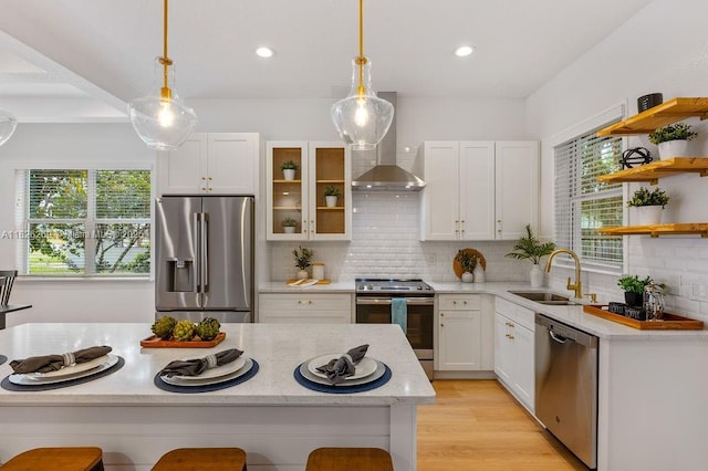 2607 Lafayette Ave, Winter Park, FL 32789 - kitchen featuring stainless steel appliances, wall chimney range hood, white cabinets, pendant lighting, and decorative backsplash