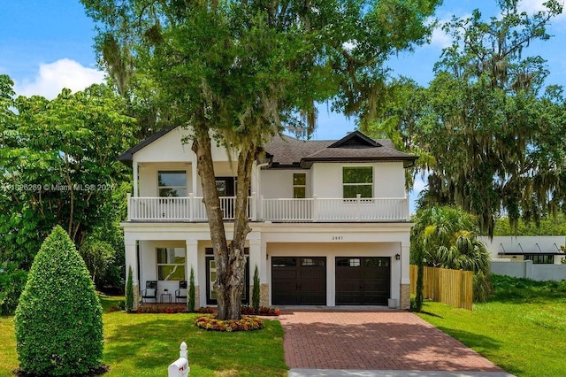 2607 Lafayette Ave, Winter Park, FL 32789 - view of front of house with a balcony, stucco siding, decorative driveway, an attached garage, and covered porch