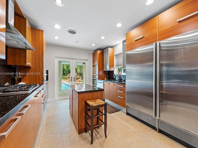 13530 SW 77th Ave, Pinecrest, FL 33156 - kitchen with stainless steel appliances, wall chimney exhaust hood, french doors, modern cabinets, and a center island
