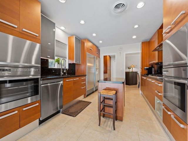 13530 SW 77th Ave, Pinecrest, FL 33156 - kitchen with appliances with stainless steel finishes, modern cabinets, recessed lighting, a center island, and brown cabinets