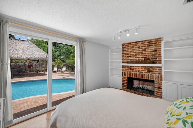 6201 SW 3rd St, Plantation, FL 33317 - bedroom featuring access to exterior, a textured ceiling, wood finished floors, and a fireplace