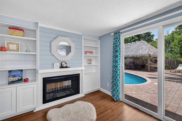 6201 SW 3rd St, Plantation, FL 33317 - living area with a textured ceiling, wood finished floors, a brick fireplace, and built in features