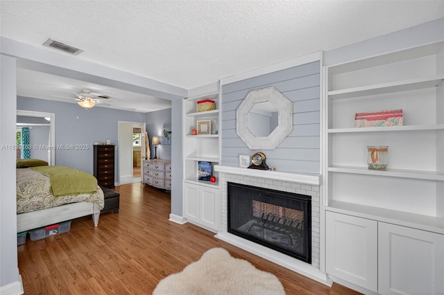 6201 SW 3rd St, Plantation, FL 33317 - bedroom featuring a fireplace, wood finished floors, a textured ceiling, and ceiling fan