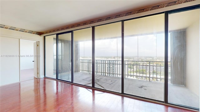 11113 Biscayne Blvd Unit 2056, Miami, FL 33181 - empty room featuring plenty of natural light, a wall of windows, and wood finished floors