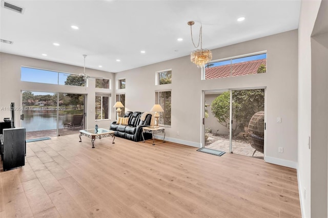 321 NW 100th Ave, Plantation, FL 33324 - living area featuring plenty of natural light, recessed lighting, wood finished floors, a chandelier, and a towering ceiling