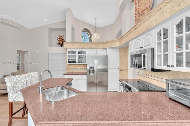 321 NW 100th Ave, Plantation, FL 33324 - kitchen featuring stainless steel appliances, high vaulted ceiling, decorative backsplash, glass insert cabinets, and a chandelier