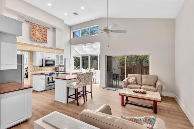 321 NW 100th Ave, Plantation, FL 33324 - living area featuring high vaulted ceiling, a ceiling fan, light wood-type flooring, and recessed lighting