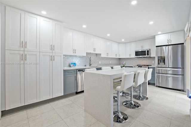 9112A SW 20th St, Davie, FL 33324 - kitchen with stainless steel appliances, light countertops, a kitchen bar, backsplash, and white cabinetry
