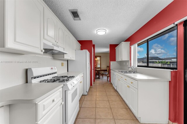 13420 SW 53rd St, Miami, FL 33175 - kitchen featuring white appliances, under cabinet range hood, light countertops, white cabinets, and light tile patterned floors