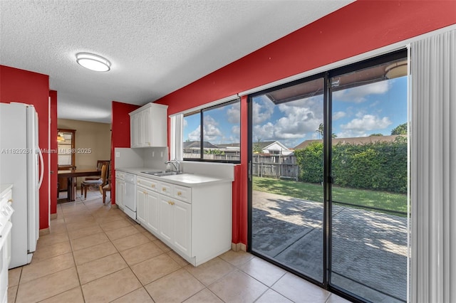 13420 SW 53rd St, Miami, FL 33175 - kitchen featuring white appliances, light countertops, white cabinets, light tile patterned floors, and a textured ceiling