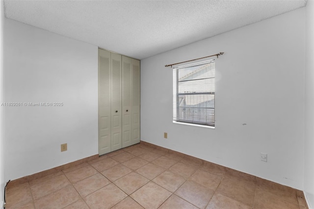 13420 SW 53rd St, Miami, FL 33175 - unfurnished bedroom featuring a closet, a textured ceiling, and light tile patterned floors