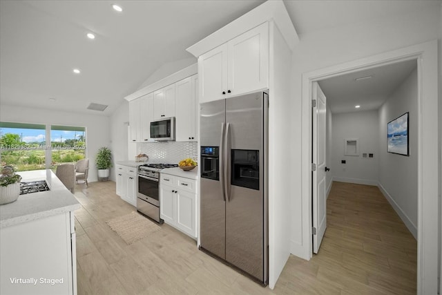 1301 NE 36th Ln, Cape Coral, FL 33909 - kitchen featuring appliances with stainless steel finishes, light wood-style floors, tasteful backsplash, white cabinets, and lofted ceiling
