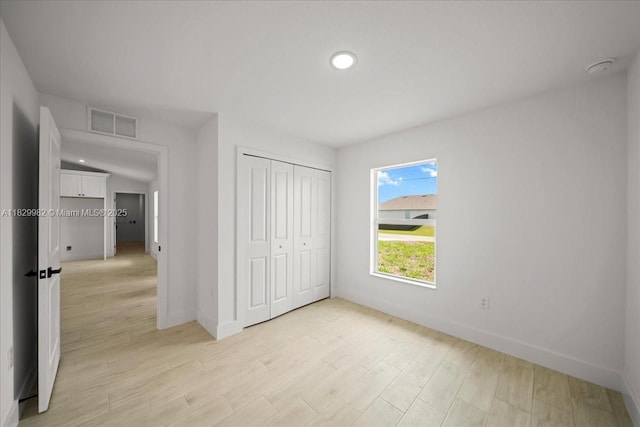 1301 NE 36th Ln, Cape Coral, FL 33909 - unfurnished bedroom featuring a closet, light wood finished floors, and recessed lighting