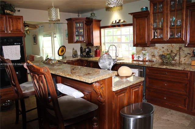 8200 SW 164th St, Palmetto Bay, FL 33157 - kitchen featuring tasteful backsplash, a kitchen breakfast bar, light stone counters, and plenty of natural light