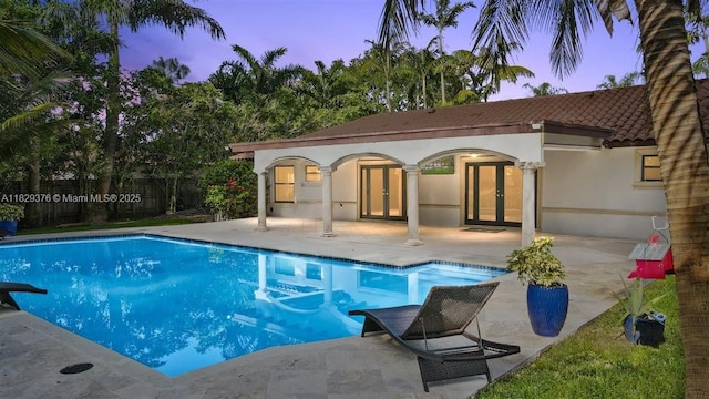 18301 SW 86th Ave, Palmetto Bay, FL 33157 - pool at dusk with french doors and a patio