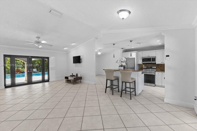 18301 SW 86th Ave, Palmetto Bay, FL 33157 - kitchen with appliances with stainless steel finishes, crown molding, a kitchen breakfast bar, open floor plan, and a textured ceiling