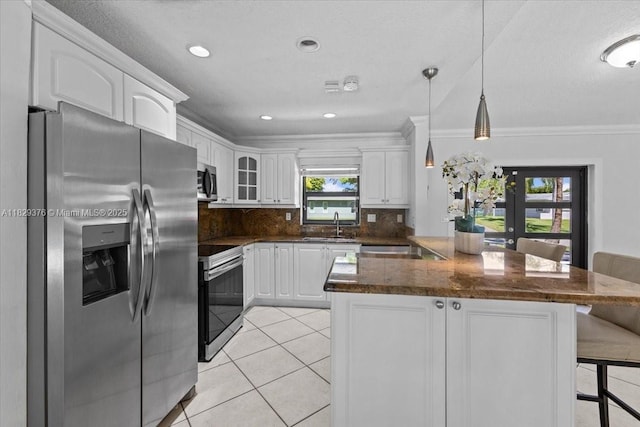 18301 SW 86th Ave, Palmetto Bay, FL 33157 - kitchen with appliances with stainless steel finishes, white cabinetry, a breakfast bar area, light tile patterned floors, and backsplash