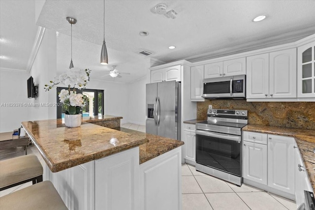 18301 SW 86th Ave, Palmetto Bay, FL 33157 - kitchen featuring stainless steel appliances, a center island, a kitchen bar, white cabinets, and tasteful backsplash