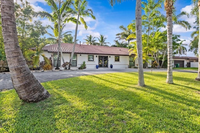 18301 SW 86th Ave, Palmetto Bay, FL 33157 - view of front of house featuring a tile roof, stucco siding, a front yard, and french doors