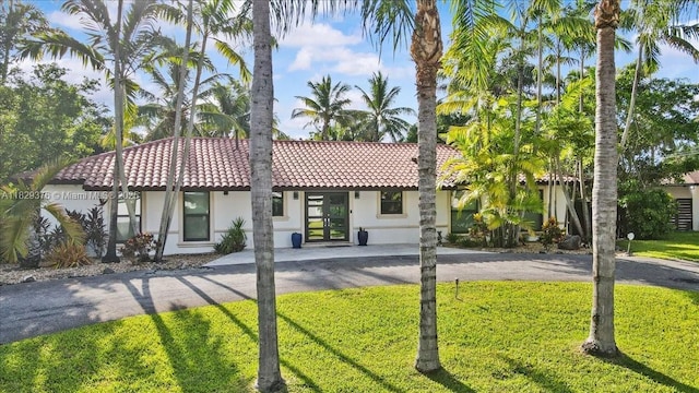18301 SW 86th Ave, Palmetto Bay, FL 33157 - mediterranean / spanish house with a tile roof, stucco siding, a front lawn, and french doors