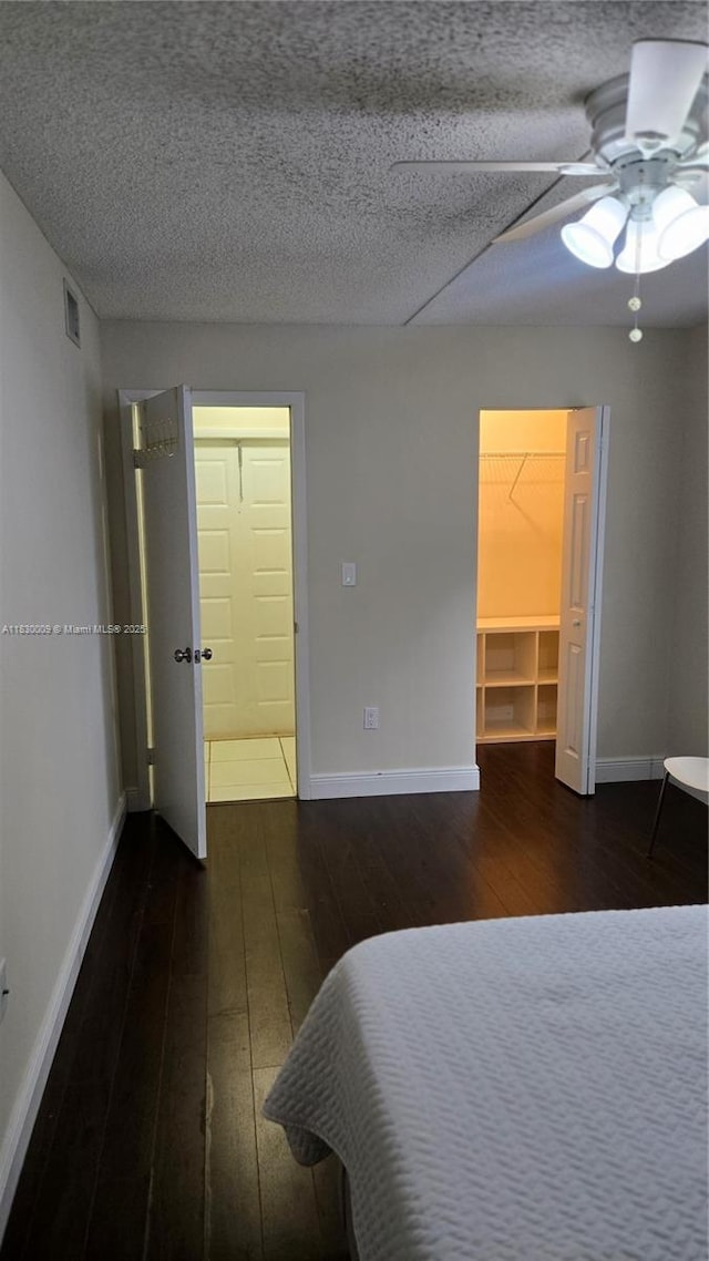 7500 NW 17th St Unit 101, Plantation, FL 33313 - bedroom with hardwood / wood-style floors, a spacious closet, ceiling fan, and a textured ceiling