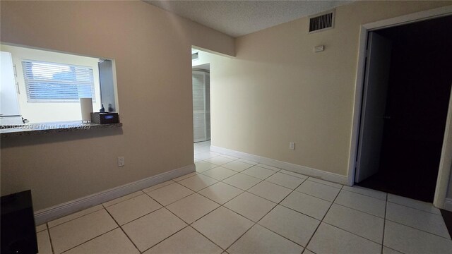 7500 NW 17th St Unit 101, Plantation, FL 33313 - empty room featuring light tile patterned flooring and a textured ceiling