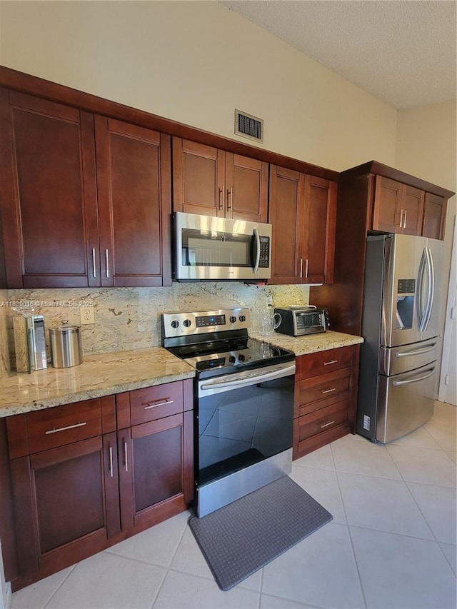 810 SW 113th Ter, Pembroke Pines, FL 33025 - kitchen with stainless steel appliances, decorative backsplash, dark brown cabinets, light tile patterned floors, and a textured ceiling