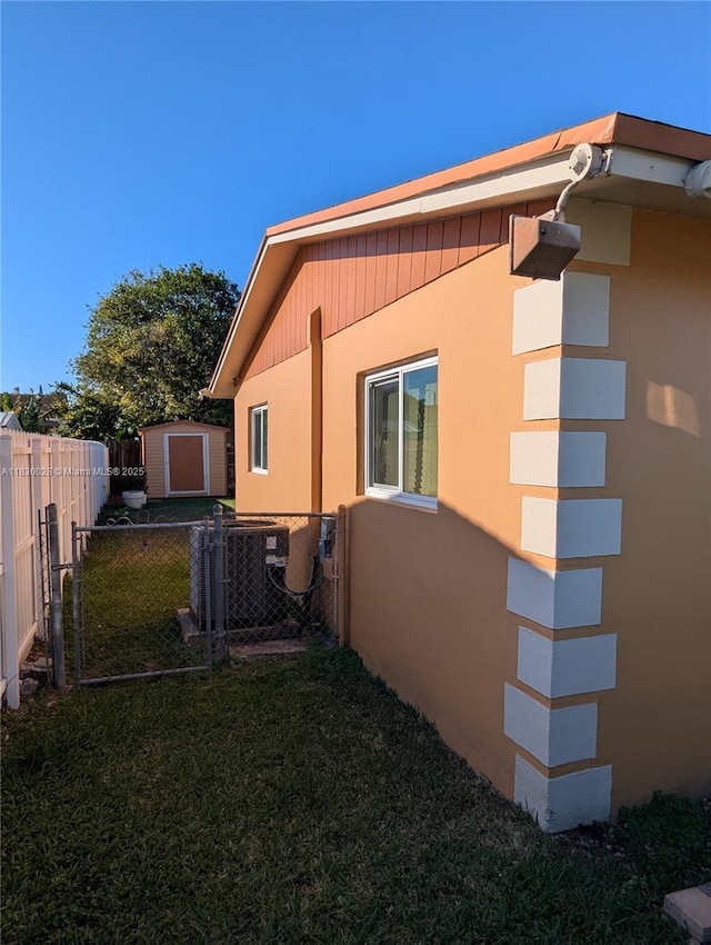 11024 SW 157th Ter, Miami, FL 33157 - view of side of home with a storage unit, stucco siding, and a fenced backyard