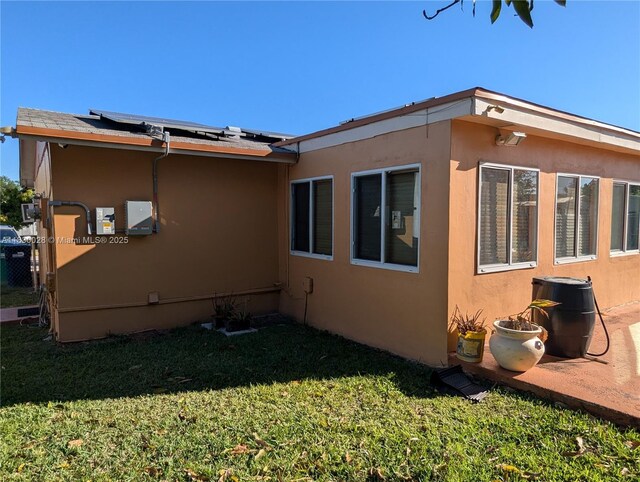 11024 SW 157th Ter, Miami, FL 33157 - view of side of home with a lawn, stucco siding, and solar panels