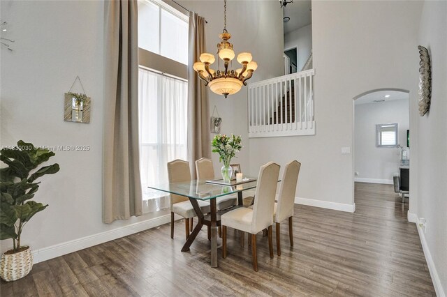 5347 SW 32nd Ter, Hollywood, FL 33312 - dining area featuring a high ceiling, a chandelier, arched walkways, and wood finished floors