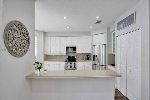 5347 SW 32nd Ter, Hollywood, FL 33312 - kitchen with appliances with stainless steel finishes, white cabinets, light countertops, a peninsula, and recessed lighting