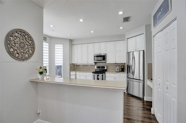 5347 SW 32nd Ter, Hollywood, FL 33312 - kitchen featuring stainless steel appliances, white cabinets, light countertops, a peninsula, and recessed lighting