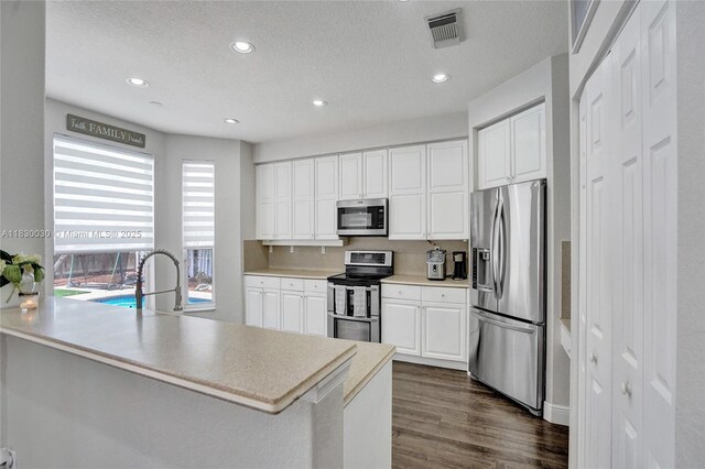 5347 SW 32nd Ter, Hollywood, FL 33312 - kitchen featuring stainless steel appliances, a textured ceiling, white cabinets, a peninsula, and recessed lighting