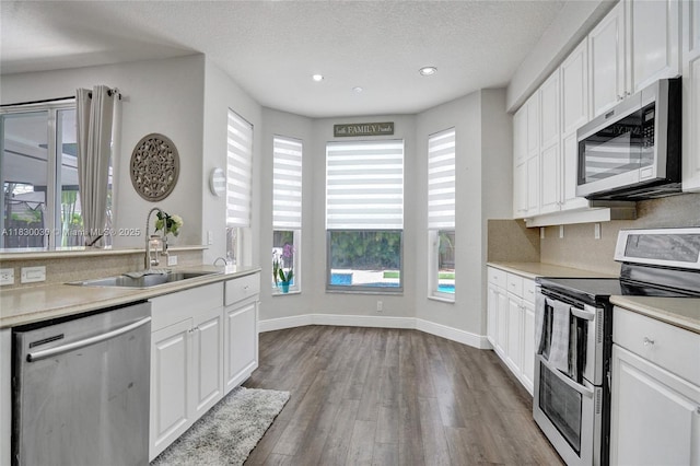 5347 SW 32nd Ter, Hollywood, FL 33312 - kitchen with stainless steel appliances, dark wood-style floors, white cabinetry, recessed lighting, and light countertops