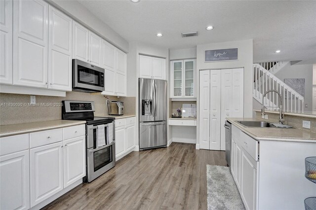 5347 SW 32nd Ter, Hollywood, FL 33312 - kitchen featuring stainless steel appliances, light wood-style floors, recessed lighting, and white cabinets