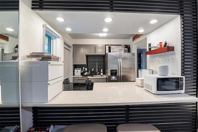 1060 Pennsylvania Ave Unit 7, Miami Beach, FL 33139 - kitchen with stainless steel fridge, white microwave, cooktop, recessed lighting, and gray cabinetry