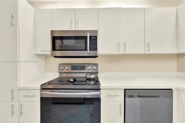 10217 NW 24th Pl Unit 310, Sunrise, FL 33322 - kitchen featuring appliances with stainless steel finishes, light countertops, and white cabinetry