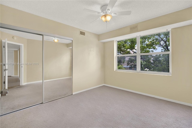 10217 NW 24th Pl Unit 310, Sunrise, FL 33322 - unfurnished bedroom featuring carpet, multiple windows, a textured ceiling, a closet, and ceiling fan