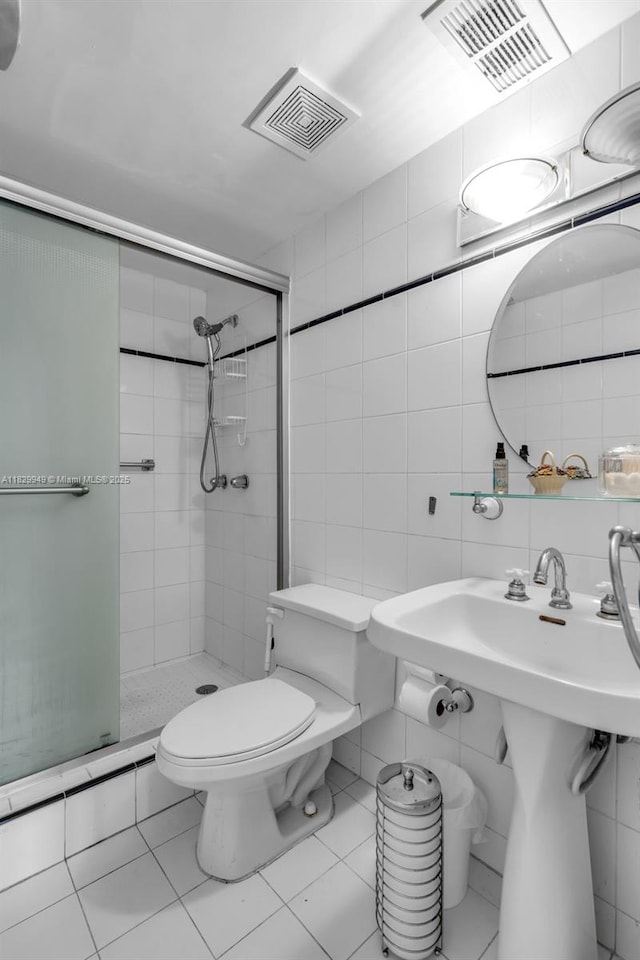 1345 Lincoln Rd Unit 1005, Miami Beach, FL 33139 - bathroom featuring a stall shower, tile walls, tile patterned flooring, and backsplash