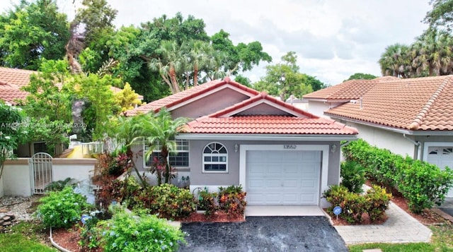 13552 NW 5th Ct, Plantation, FL 33325 - mediterranean / spanish-style home with a tiled roof, asphalt driveway, an attached garage, and stucco siding