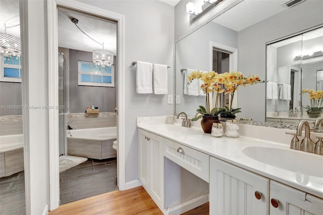 13552 NW 5th Ct, Plantation, FL 33325 - bathroom with a chandelier, wood finished floors, a garden tub, and double vanity