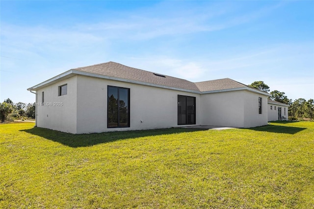 933 Gleason St, Lehigh Acres, FL 33974 - rear view of house with a lawn, stucco siding, and roof with shingles