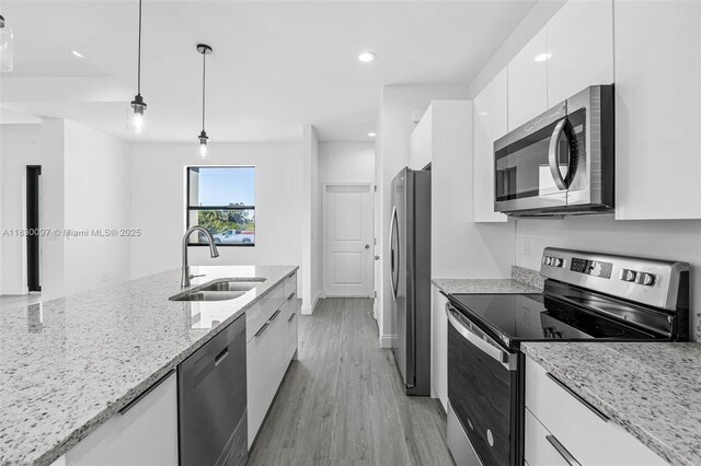 933 Gleason St, Lehigh Acres, FL 33974 - kitchen with appliances with stainless steel finishes, modern cabinets, white cabinets, light wood-style flooring, and hanging light fixtures